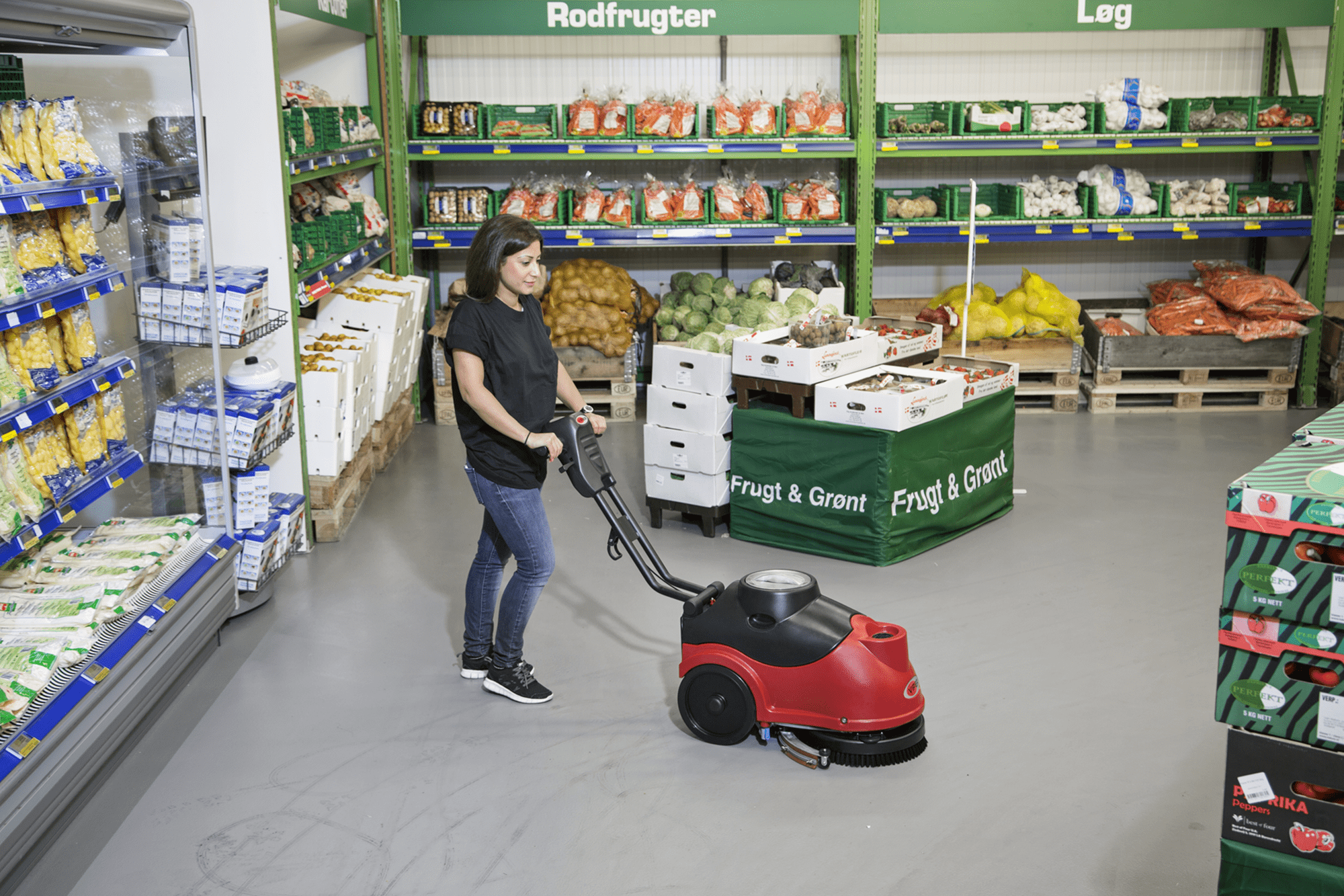 Woman operating Viper Fang Micro Floor Scrubber in a grocery store