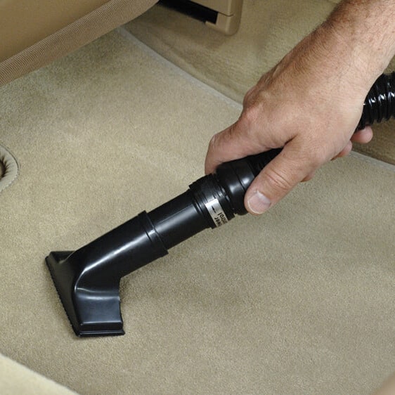 MetroVac Vac N Blog Auto Vacuum - This image shows an auto detailer cleaning the carpet of a car with the MetroVac Vac N Blo auto vacuum.