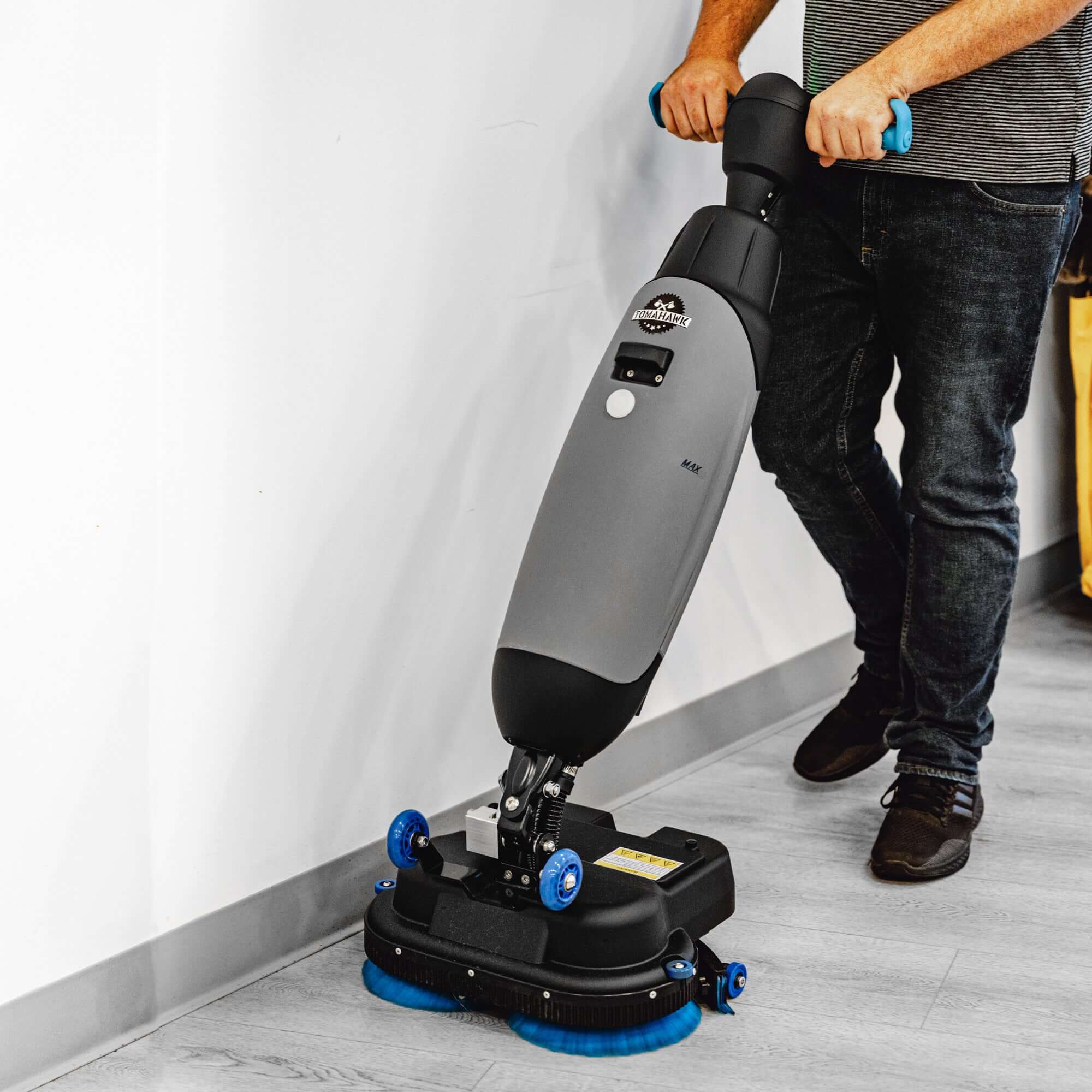 Man pushing Tomahawk Electric Floor Scrubber Cleaner with 18” Power Mop Brushes Cordless 36V Battery Powered